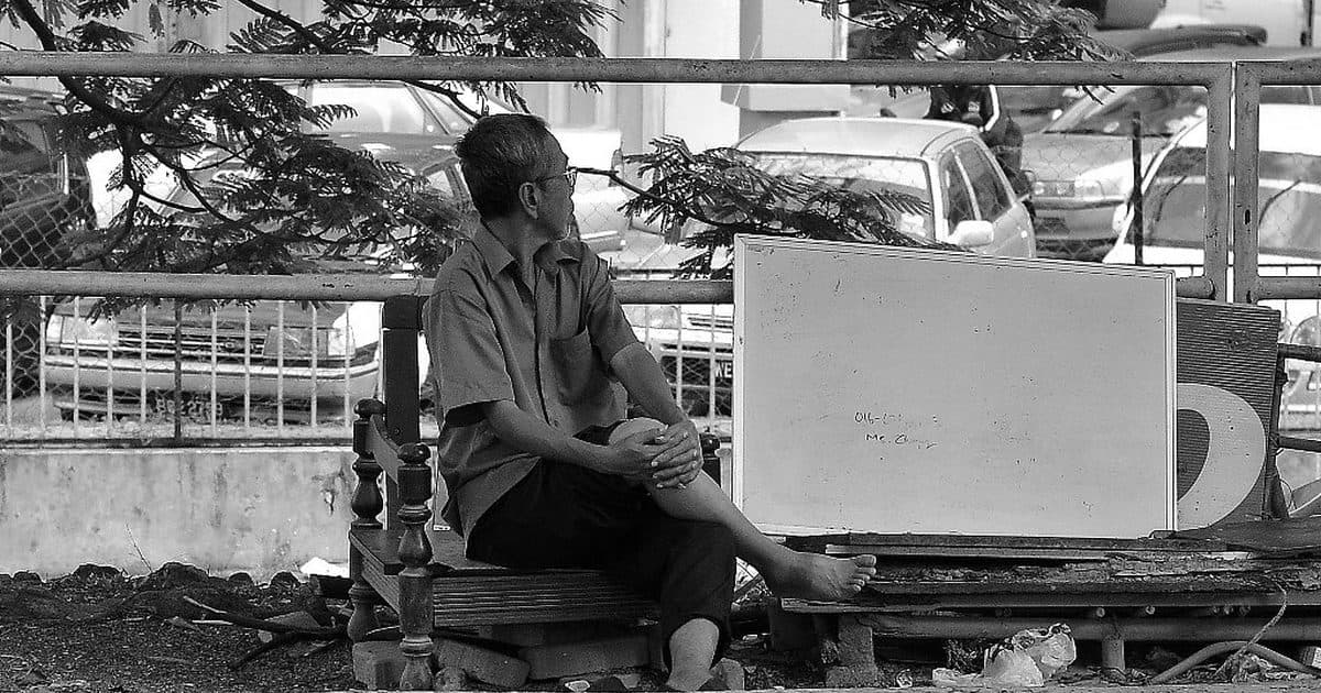 Elderly person resting on a bench in Malaysia
