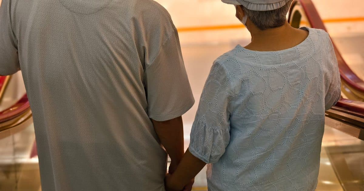 Senior couple holding hands on an escalator