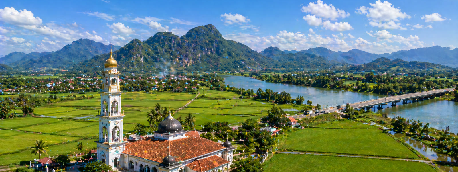 Kedah paddy fields with mosque and mountain backdrop